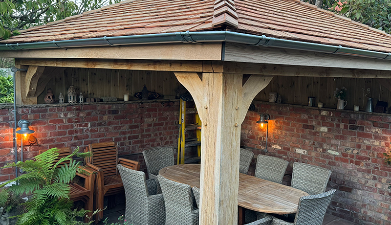 Timber gazebo with slate roof over outdoor dining